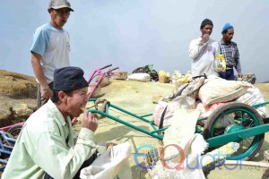 MENIKMATI SNACK. Istirahat siang dimanfaatkan penambang belerang Kawah Ijen untuk makan dan bersenda gurau