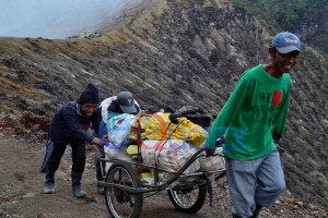 SEMANGAT DORONG. Semangat kebersamaan mendorong roda bermuatan belerang menghilangkan rasa kelelahan di Ijen, banyuwangi, jatim, Kamis