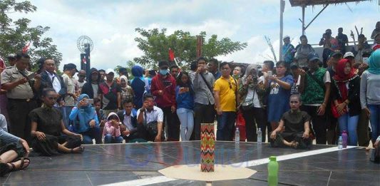 Salah seorang pengunjung mencoba fenomena telur berdiri tegak di Tugu Khatulistiwa