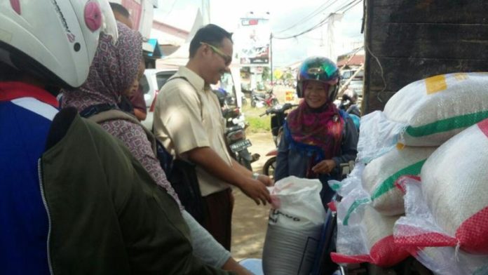 Warga yang membeli beras di lokasi operasi pasar Bulog di halaman kantor PKK, Sekadau