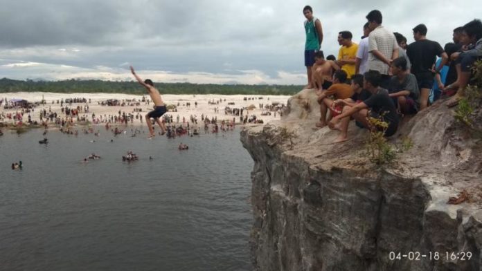 SERASA DI PANTAI. Ribuan orang berkunjung ke lokasi TTM di Desa Mandor Kecamatan Mandor Kabupaten Landak, Minggu (4/2). Tak seorang sedang terjun dari ketinggian ke danau akibat bekas pertambangan emas. Antonius-RK