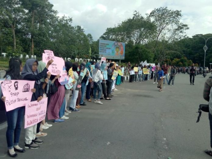 AKSI DAMAI. Puluhan perempuan mengatasnamakan Women’s March Pontianak menyampaikan menggelar aksi damai di Digulis Untan, Kamis (8/3) sore. Foto Ambrosius Junius-RK