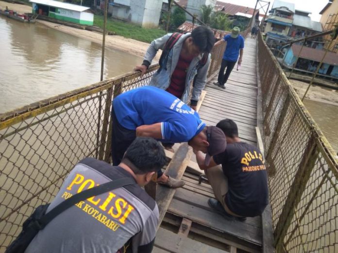 Perbaiki Jembatan. Anggota Polsek Kota Baru bersama masyarakat memperbaiki lantai jembatan gantung penghubung Desa Tanjung Gunung dengan ibu kota Kecamatan Kota Baru. Polsek Kota Baru for Rakyat Kalbar