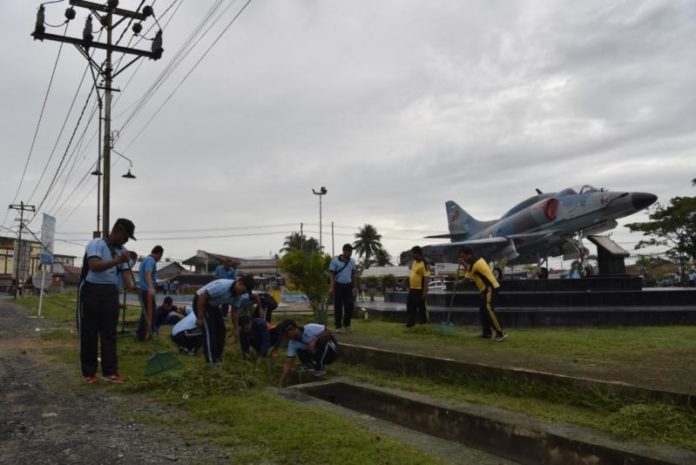 GOTONG ROYONG. Di bawah awan gelap, personel Lanud Supadio bersama instansi di sekitarnya gotong royong membersihkan Taman Dirgantara, Kubu Raya Selasa (13/3)--Penerangan Lanud Supadio for RK