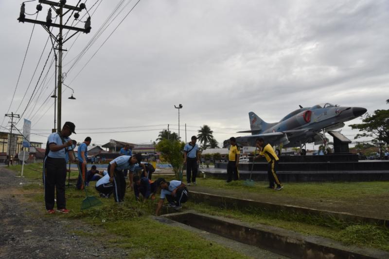 GOTONG ROYONG. Di bawah awan gelap, personel Lanud Supadio bersama instansi di sekitarnya gotong royong membersihkan Taman Dirgantara, Kubu Raya Selasa (13/3)--Penerangan Lanud Supadio for RK