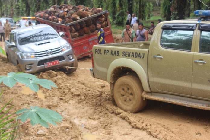 TERSENDAT : Mobil milik pejabat Pemkab Sekadau terjebak kubangan lumpur di Jalan Akses Belitang, belum lama ini. Tahun ini, ruas jalan tersebut akan diperbaiki. Abdu Syukri