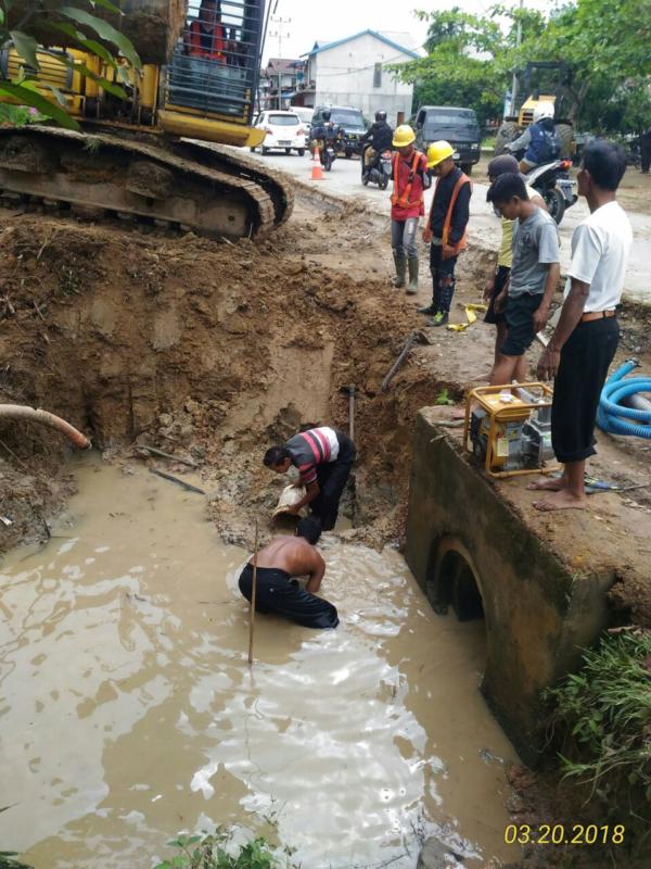 PECAH. Teknisi PDAM Sirin Meragun memperbaiki pipa induk yang pecah, setelah terkeruk ekskavator Proyek Pelebaran Jalan Nasional, Senin sore (19//3). Abdu Syukri Insert: Direktur PDAM Sirin Meragun, Yok Kelak ST. Abdu Syukri