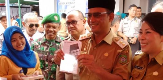 Singkawang Book Fair Resmi Dibuka BUKA KEGIATAN. Didampingi Tjhai Chui Mie dan Wakil Walikota Singkawang Irwan menunjukkan salah satu buku di stand Singkawang Book Fair 2018, Senin (12/3)—Suhendra/RK