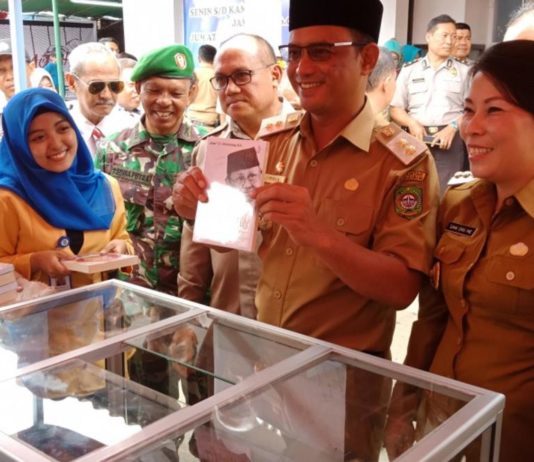 Singkawang Book Fair Resmi Dibuka BUKA KEGIATAN. Didampingi Tjhai Chui Mie dan Wakil Walikota Singkawang Irwan menunjukkan salah satu buku di stand Singkawang Book Fair 2018, Senin (12/3)—Suhendra/RK