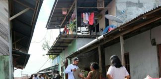 Relawan Bagikan Atribut Midji-Norsan ke Masyarakat Pinggir Sungai Kapuas Relawan Midji Norsan lakukan sosialisasi dan membahagikan atribut kepada warga. Kang Enchus for Equator.