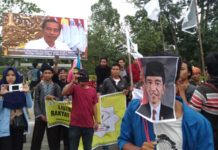 Tolak Harga BBM Naik di Bawah “Tatapan Jokowi” CATATAN UNTUK JOKOWI. Mahasiswi-mahasiswi ini tengah menujukkan kalimat-kalimat penolakan kenaikan BBM yang tertulis di karton dalam aksi damai di Taman Digulis Untan Pontianak, Jumat (30/3) sore. Saat karton itu diangkat, Jokowi tampak sedang ‘menatapi’ aksi itu dalam sebuah videotron iklan di lokasi aksi—Ocsya Ade CP