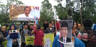 Tolak Harga BBM Naik di Bawah “Tatapan Jokowi” CATATAN UNTUK JOKOWI. Mahasiswi-mahasiswi ini tengah menujukkan kalimat-kalimat penolakan kenaikan BBM yang tertulis di karton dalam aksi damai di Taman Digulis Untan Pontianak, Jumat (30/3) sore. Saat karton itu diangkat, Jokowi tampak sedang ‘menatapi’ aksi itu dalam sebuah videotron iklan di lokasi aksi—Ocsya Ade CP