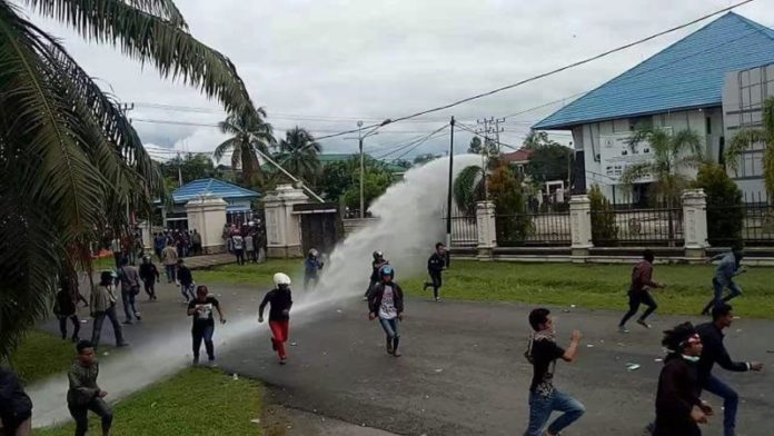 BERHAMBURAN. Massa berlarian menghindari tembakan water canon dan gas air mata yang dilontarkan kepolisian di gedung DPRD Kapuas Hulu, Selasa (24/4). Andreas-RK