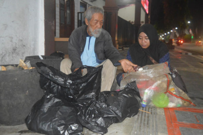 MEMILIH BARANG BEKAS. Soesilo Toer (kiri) saat memulung sampah ditemani wartawan Jawa Pos Radar Kudus, di Blora, baru-baru ini. Radar Kudus Photo