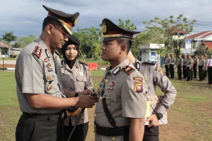 LEPASA JABATAN. Kapolres Singkawang AKBP Yury Nur Hidayat melepaskan tanda jabatan Kasat Lantas Polres Singkawang, AKP Priyanto di halaman Mapolres Singkawang, Senin (10/4)—Polres Singkawang for RK