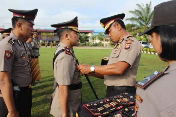 SERTIJAB. AKBP Imam Riyadi melepas dan memasang tanda jabatan pada pejabat Polres Kapuas Hulu yang dimutasi di halaman Mapolres, Rabu (11/4). Andreas-RK