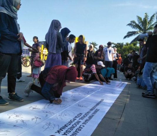 Tiga Napi Teroris Tak Bisa Nyoblos TANDA TANGAN. Warga menandatangani Deklarasi Pilkada Damai di kain putih sepanjang lima meter di kawasan Digulis Untan Pontianak, Minggu pagi (22/4). Gusnadi-RK