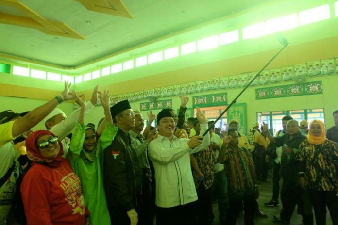 Calon Gubernur Kalbar nomor urut tiga Sutarmidji - Ria Norsan berselfie bersama masyarakat Putusibau. (Kang Enchus for Equator)