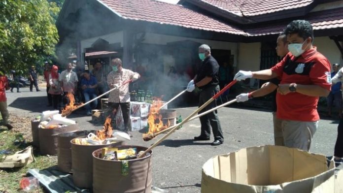 TAK LAYAK EDAR. Kepala Dinas Koperasi UMK, Industri dan Perdagangan (Diskumindag) Kabupaten Sambas Ir Musanif bersama Tim Satgas Pangan Kabupaten Sambas melaksanakan pemusnahan makanan dan minuman tak layak edar, Kamis (19/4) di halaman Diskumindag Sambas. Sairi/Rakyat Kalbar