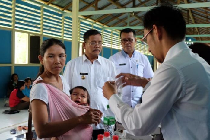 VAKSINASI. Bupati Sekadau, Rupinus memantau proses vaksinasi pasien campak di Landau Mentawa, beberapa waktu lalu. Humas Pemkab Sekadau for RK