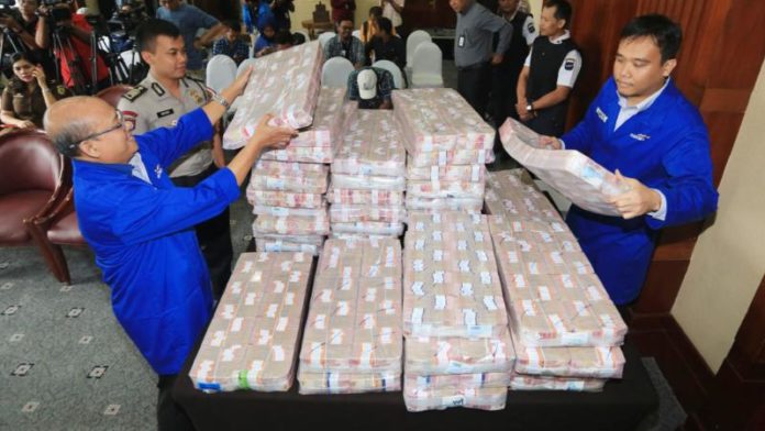 DUIT SAMADIKUN. Petugas cash center Bank Mandiri dan kepolisian menata kemasan uang tunai dari Samadikun Hartono sebesar Rp87 miliar, Kamis (17/5), di Plaza Mandiri Jakarta. Muhamad Ali-Jawa Pos