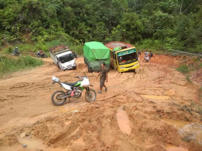 Terjebak Lubang. Truk bermuatan terjebak di jalan yang rusak berat dan berlubang di jalur Sayan-Nanga Pinoh, Rabu (23/5). Zulfilza Hamsu for Rakyat Kalbar