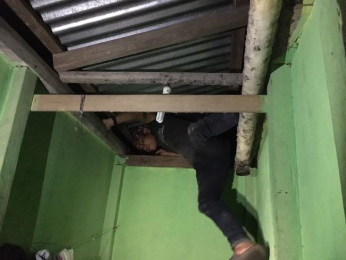 SEMBUNYI. Takut dirazia, salah seorang penghuni hotel bersembunyi di atas dek di salah satu hotel di Entikong, Sabtu (19/5) malam—Polisi for RK