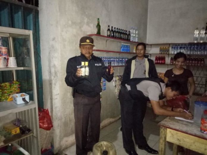 OPERASI. Kapolsek Sengah Temila Iptu Sujiyanto saat menunjukkan miras yang disita dari warung di Pahauman--Polsek for Rakyat Kalbar