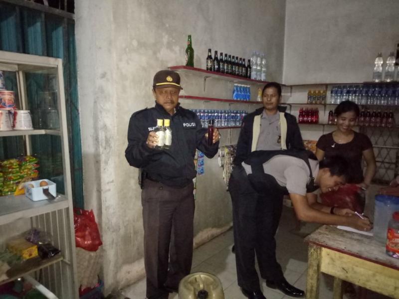 OPERASI. Kapolsek Sengah Temila Iptu Sujiyanto saat menunjukkan miras yang disita dari warung di Pahauman--Polsek for Rakyat Kalbar