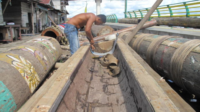 SIAP-SIAP DENGAR BUM. Salah seorang warga dari Kelompok Meriam Karbit Setia Tambelan, Pontianak Timur, sedang memasang seng sebagai alas untuk menghindari rembesan air yang nantinya dicampur karbit sebagai amunisi, yang bakal menghasilkan suara menggelar, Sabtu (19/5). Maulidi Murni-RK