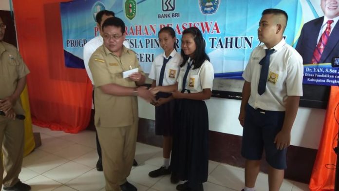 TERIMA BANTUAN. Salah seorang siswa SMPN 1 Lumar menerima bantuan beasiswa PIP di Aula Sekolah, Senin (14/5) pagi—Kurnadi/RK