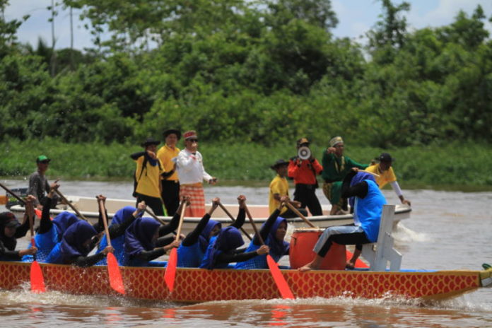 BERTANDING. Para pendayung dragon boat ini tengah mengejar garis finish dalam perlombaan yang digelar pada Pekan Gawai Rakyat, Desa Rasau Jaya Umum, Kubu Raya, yang ke 15, Minggu (29/4). Ocsya Ade CP/RK