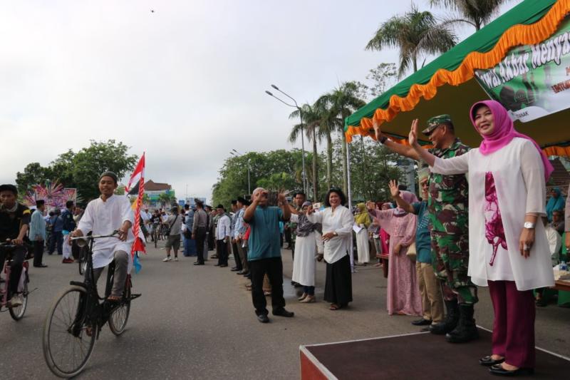 LAMBAIAN TANGAN. Mahmudah melambaikan tangan melepas peserta pawai akbar di depan Kantor Wali Kota Pontianak Jalan Rahadi Usman, Minggu (13/5). Gusnadi-RK