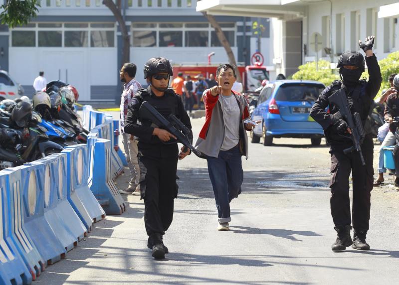 LEDAKAN DI MARKAS POLISI. Satuan tim anggota Polrestabes Surabaya hendak mengamankan area steril 200 meter dari lokasi ledakan di pos Polrestabes Surabaya, Senin (14/5). Dipta Wahyu-Jawa Pos