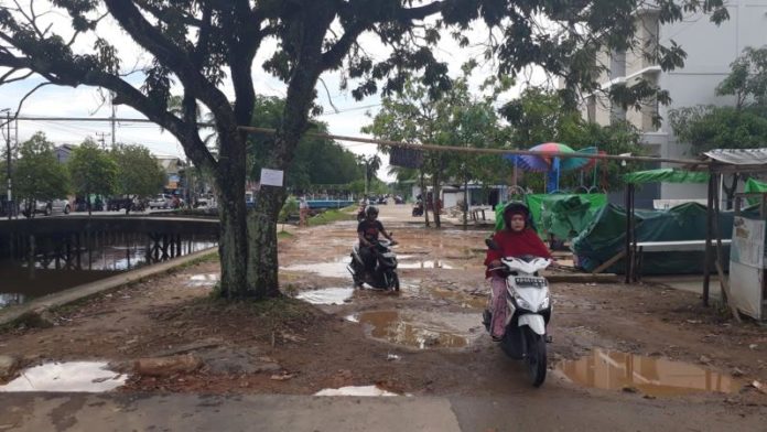 TERGENANG. Salah satu titik Jalan Paralel Sungai Jawi yang berlobang dan tergenang, Minggu (20/5). Gusnadi-RK