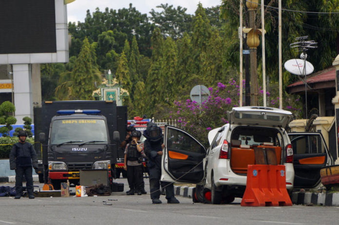 PERIKSA MOBIL. Tim Jibom Gegana Brimob Polda Riau memeriksa Avanza yang digunakan para terduga teroris yang berupaya menyerang Markas Polda Riau, Rabu (16/5). Defizal