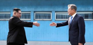 Trump Kecele Lagi DAMAI DALAM PROSES. Pemimpin Korea Utara, Kim Jong-Un (kiri) berjabat tangan dengan Presiden Korea Selatan Moon Jae, di atas garis demarkasi militer di desa perbatasan, Panmunjom, di Zona Demiliterisasi. Korea Summit Press/AP