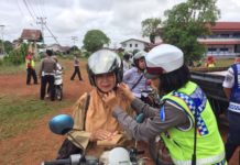 Penilangan Selalu Ada TEGUR. Polwan dari Sat Lantas Polres Kapuas Hulu mencontohkan pemasangan helm dengan benar kepada salah satu pengendara yang diberi teguran dalam Operasi Patuh Kapuas 2018, belum lama ini--Polisi for RK