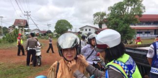 Penilangan Selalu Ada TEGUR. Polwan dari Sat Lantas Polres Kapuas Hulu mencontohkan pemasangan helm dengan benar kepada salah satu pengendara yang diberi teguran dalam Operasi Patuh Kapuas 2018, belum lama ini--Polisi for RK