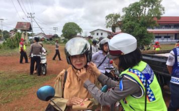 Penilangan Selalu Ada TEGUR. Polwan dari Sat Lantas Polres Kapuas Hulu mencontohkan pemasangan helm dengan benar kepada salah satu pengendara yang diberi teguran dalam Operasi Patuh Kapuas 2018, belum lama ini--Polisi for RK