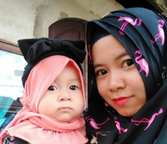 Hijab Sederhana di Hari Raya Mengenakan hijab, Sri Azizah Kurniawati bersama putrinya, Anaya dan suami tercinta, Kurniawan saat momen Hari Raya Idulfitri 1439 Hijriah di Gang Hanura, Jalan Ujung Pandang, Kecamatan Pontianak Kota, Kota Pontianak, Jumat (15/6). Kamiriluddin/Rakyat Kalbar