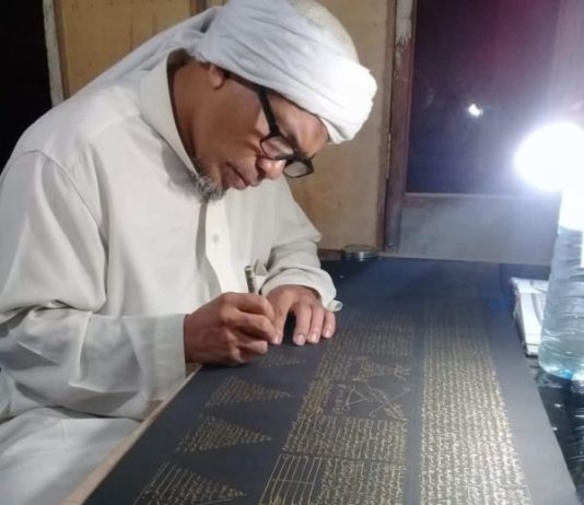 Menulis Rajah Datangkan Berkah MENULIS AYAT ALQURAN. Usman Khalid sedang menyelesaikan rajah ayat suci Alquran di sebuah kertas di rumahnya, Desa Langko, Kecamatan Lingsar, Lobar. Lombok Pos Photo