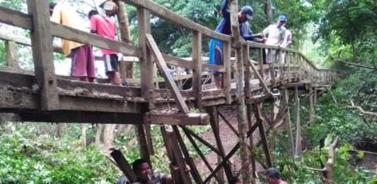 Jembatan Sungai Kempas Nyaris Ambruk Jembatan Rusak. Warga berjibaku melakukan perbaikan sementara agar jembatan Sungai Kempas tetap bisa dilalui warga, Kamis (28/6). Handika for Rakyat Kalbar