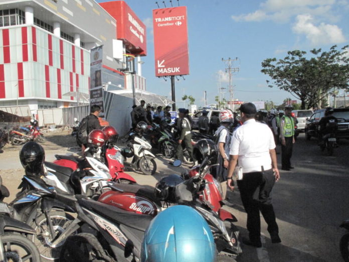 LANGGAR ATURAN. Petugas menertibkan parkir liar di badan jalan depan Transmart Kubu Raya, Selasa (5/5). Maulidi Murni-RK