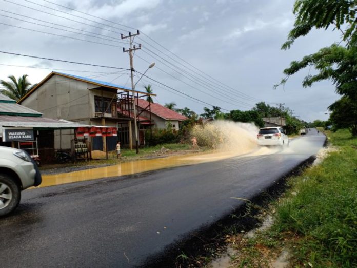 MUNCRAT. Hujan lebat menyebabkan genangan air di Jalan Sekadau-Sintang KM 6,5. Genangan air tersebut muncrat saat kendaraan melintas, Minggu pagi (24/6). Abdu Syukri