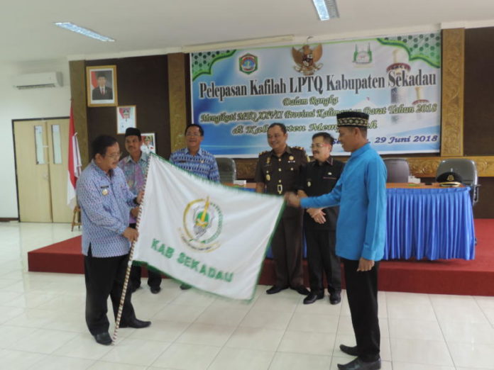 DILEPAS. Bupati Sekadau, Rupinus SH MSi menyerahkan bendera kontingen kepada Ketua Kafilah Sekadau saat acara Pelepasan Kafilah Kabupaten Sekadau di Kantor Bupati Sekadau, Jumat (29/6), sebelum menuju Kabupaten Mempawah. Abdu Syukri