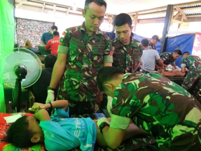 BAKSOS. Petugas tengah melakukan khitan terhadap salah satu anak peserta baksos Satgas Pamtas Yonif 511/DY di Dusun Merau, Desa Entikong, Kecamatan Entikong, Kabupaten Sanggau, Sabtu (30/6)—Yonif for RK