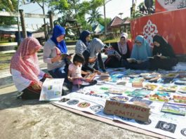 ANTUSIAS. Masyarakat dengan antusias membaca buku yang digelar Komunitas Membaca dan Perpustakaan Jalanan Singkawang di Jalan Merdeka, Singkawang, Minggu (22/7)—SUHENDRA/RK