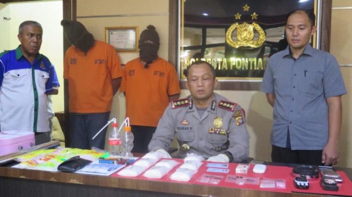 KONFERENSI PERS. Kombes Pol Wawan Kristyanto menunjukkan dua tersangka dan sejumlah barang bukti kasus penyalahgunaan dan peredaran narkoba di Mapolresta Pontianak, Selasa (24/7) sore—Andi Ridwansyah/RK