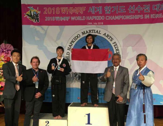 JUARA DUNIA. Devi Safitri naik podium sambil membentangkan bendera merah-putih sebagai juara pertama World Hapkido Championship Seoul 2018 di Seoul, Korea Selatan, Minggu (29/7). Humas Pemkab Kubu Raya for RK